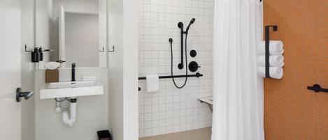 Ein modernes Badezimmer mit Waschbecken, Spiegel und Duschkabine.