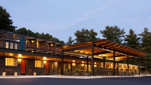 A modern hotel with multiple floors, outdoor seating, and a covered patio area.