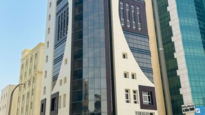 Un hotel moderno con fachada curva, múltiples ventanas y un letrero destacado.