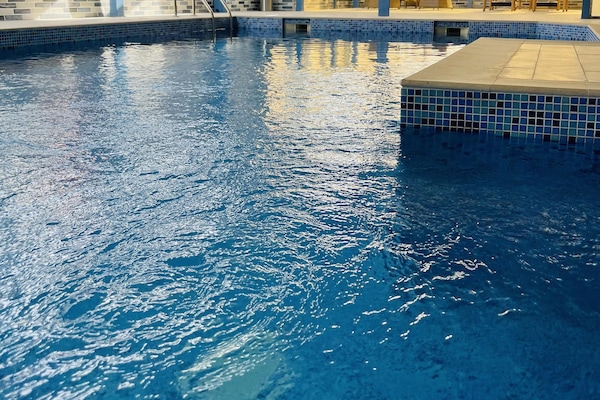 Una piscina techada, sillones reclinables de piscina