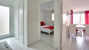 Una habitación con cama, escritorio y sillas, con vista al exterior a través de una ventana.