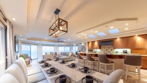 A modern kitchen with a central island, built-in appliances, and ample natural light from skylights. - Stunning Oceanfront Home w/ Panoramic Views (Oceanside)