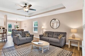 Relax in this inviting living room with two sofas, a coffee table, and a large mirror.