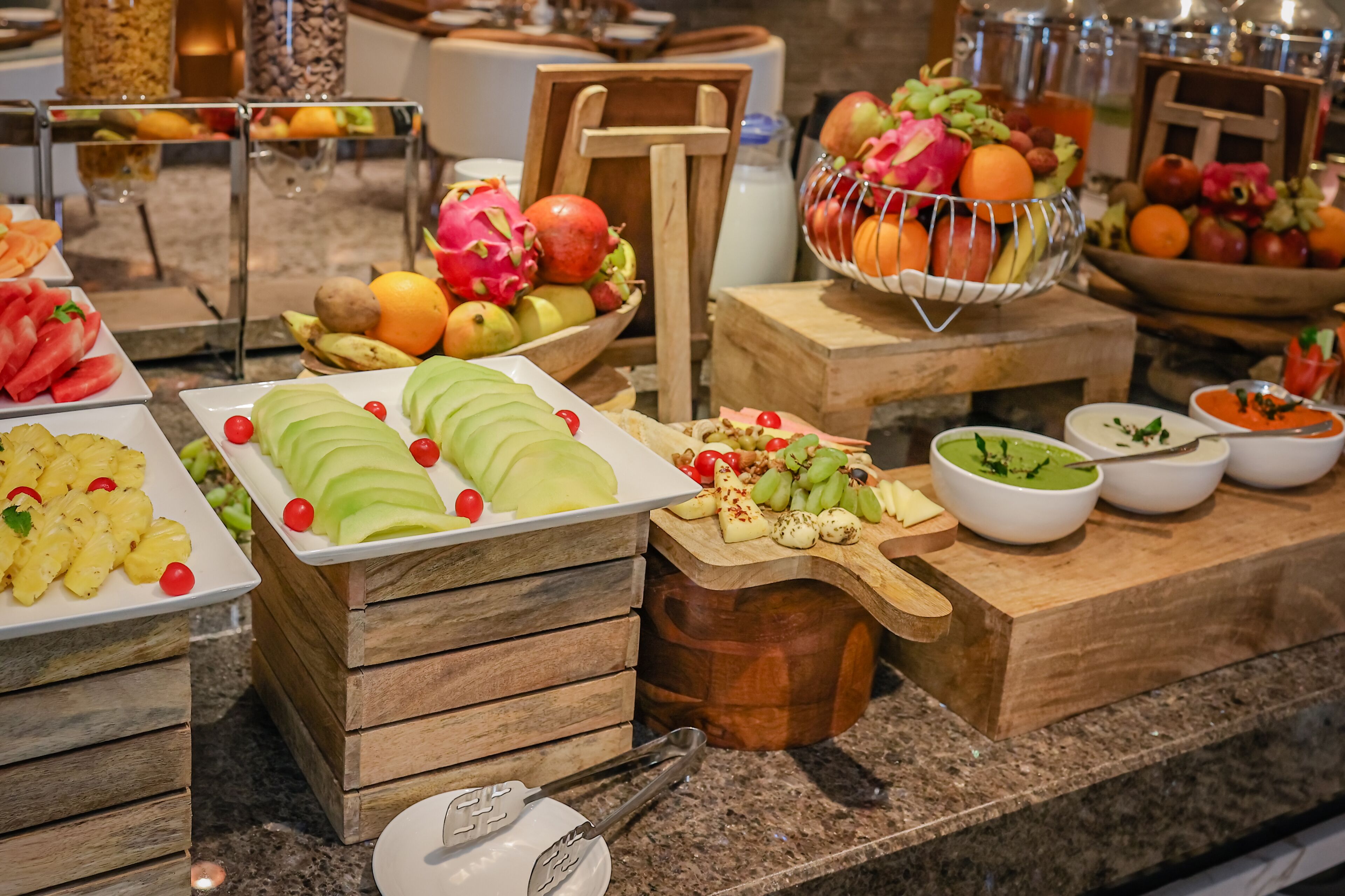 A buffet with various fruits, vegetables, and cheeses.