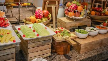 A buffet with various fruits, vegetables, and cheeses.