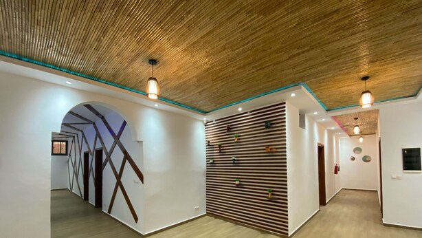 A modern interior with wooden floors, white walls, and a slatted partition wall. - FILYS HÔTEL (St. Louis)
