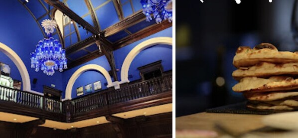Experience the grandeur of this classic space with a high ceiling and ornate chandelier, complemented by wooden beams and a balcony overlooking the room.
