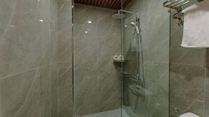 A modern bathroom with a glass-enclosed shower, a toilet, and a towel rack. - Tuan Nam Hotel (Hai Phong)