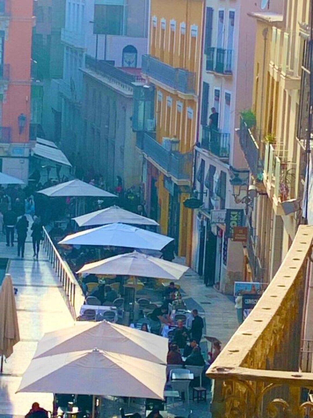 Una calle con terrazas y edificios.