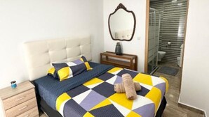 A bedroom with a bed, bedside table, and a mirror. - Suite del Ayuntamiento (Alicante (Alacant))