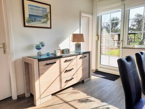 Enjoy cooking in this well-equipped kitchen with a wooden cabinet, countertop, and adjacent patio access.