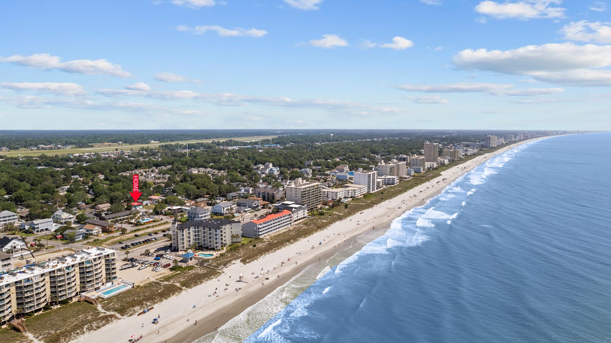 A coastal hotel with multiple floors, a beach view, and a swimming pool.