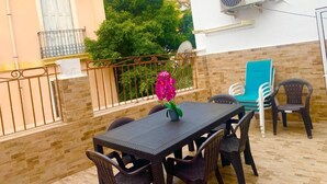 A patio with a table and chairs, a flower, and a view of mountains. - Apartment en Rambla (Alicante (Alacant))