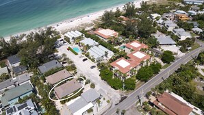 Vue aérienne d’une zone résidentielle côtière, avec des maisons, une plage et une vue dégagée sur l’océan.