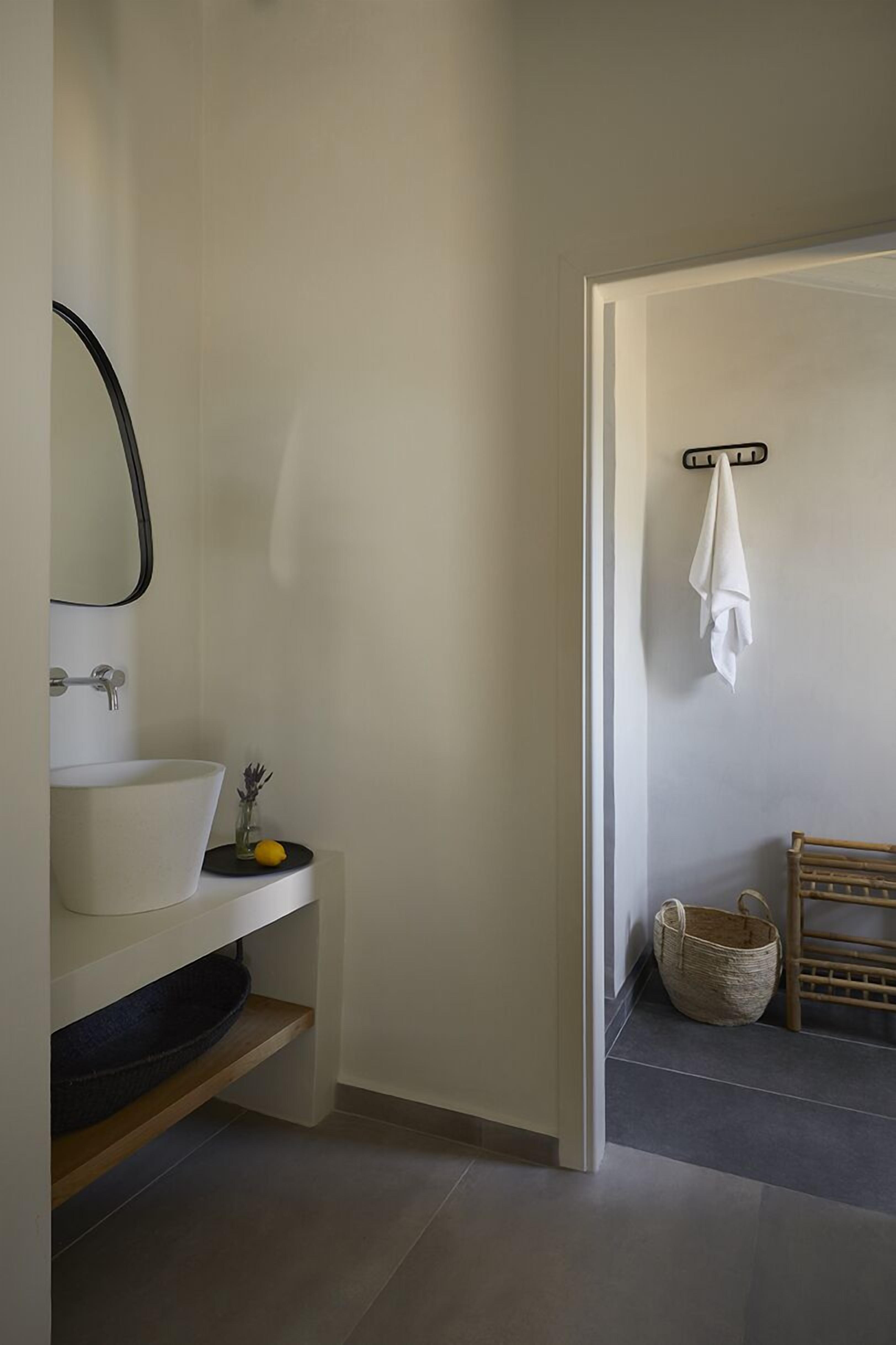 A bathroom with a white sink, mirror, and a towel rack.
