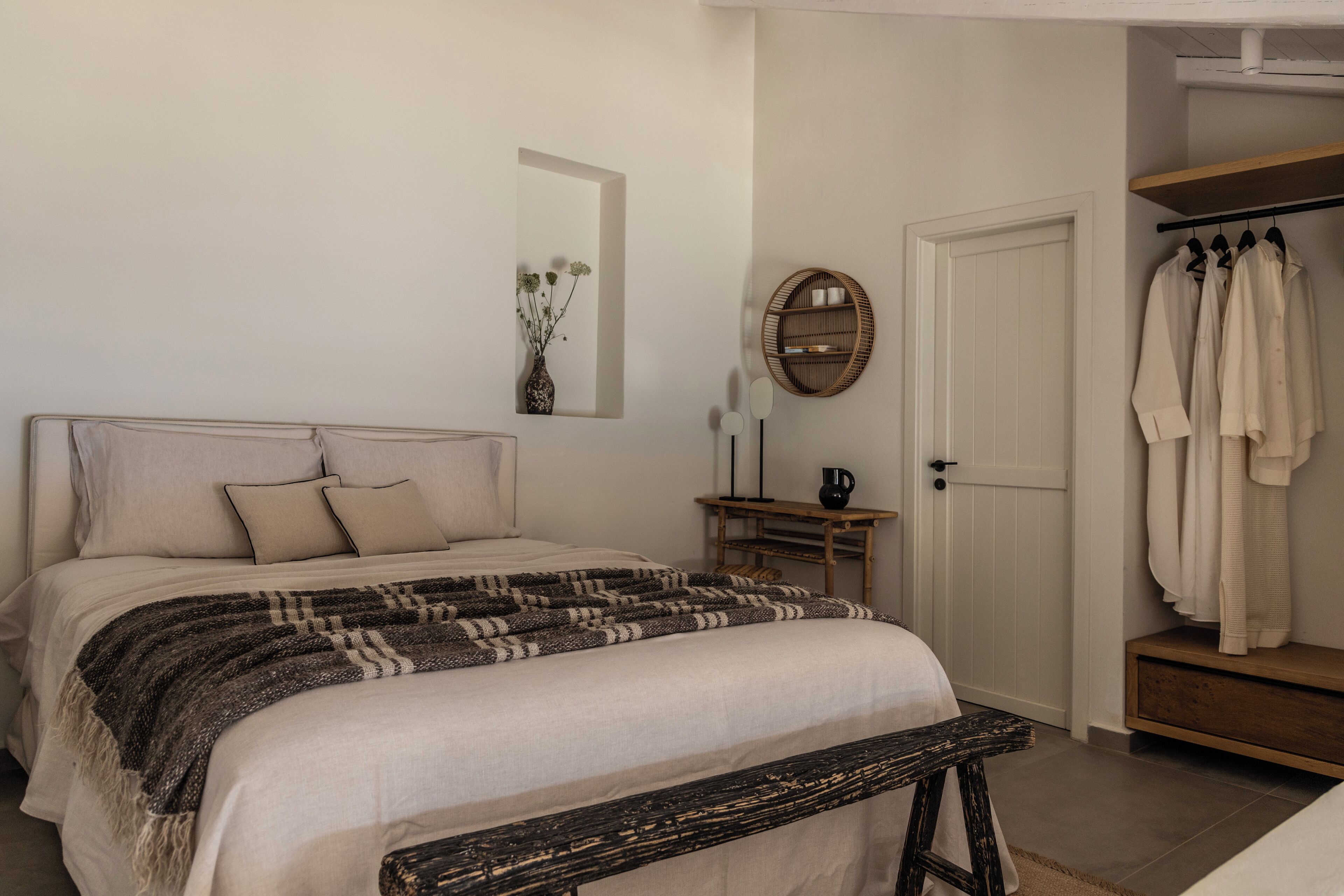 A bedroom with a bed, bedside table, and a wardrobe.