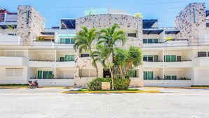 A modern building with a stone facade, multiple balconies, and a sign reading "The Meridiana."