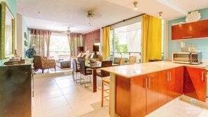 A spacious kitchen with a central island, wooden cabinets, and a microwave.