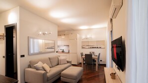 Un appartement moderne comprenant un espace de vie, une kitchenette, un coin repas et un téléviseur.