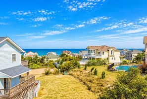 A coastal residential area with houses, a swimming pool, and a view of the ocean.