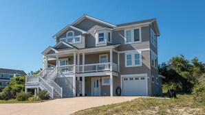A two-story house with a front porch, a staircase, and a garage.