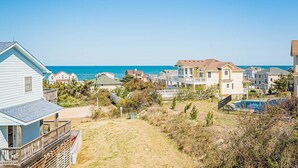A coastal residential area with houses, a beach, and a clear sky.