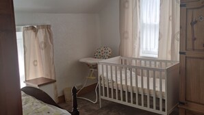 Una habitación infantil con una cuna, un cambiador y un armario de madera.