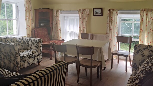 Una sala de estar acogedora con una mesa de comedor, sillas y un sofá.