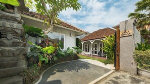Eine Villa mit Ziegeldach, einer überdachten Terrasse und einer Steintreppe.