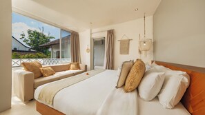 Ein Schlafzimmer mit einem großen Bett, einer Couch und Blick ins Freie.