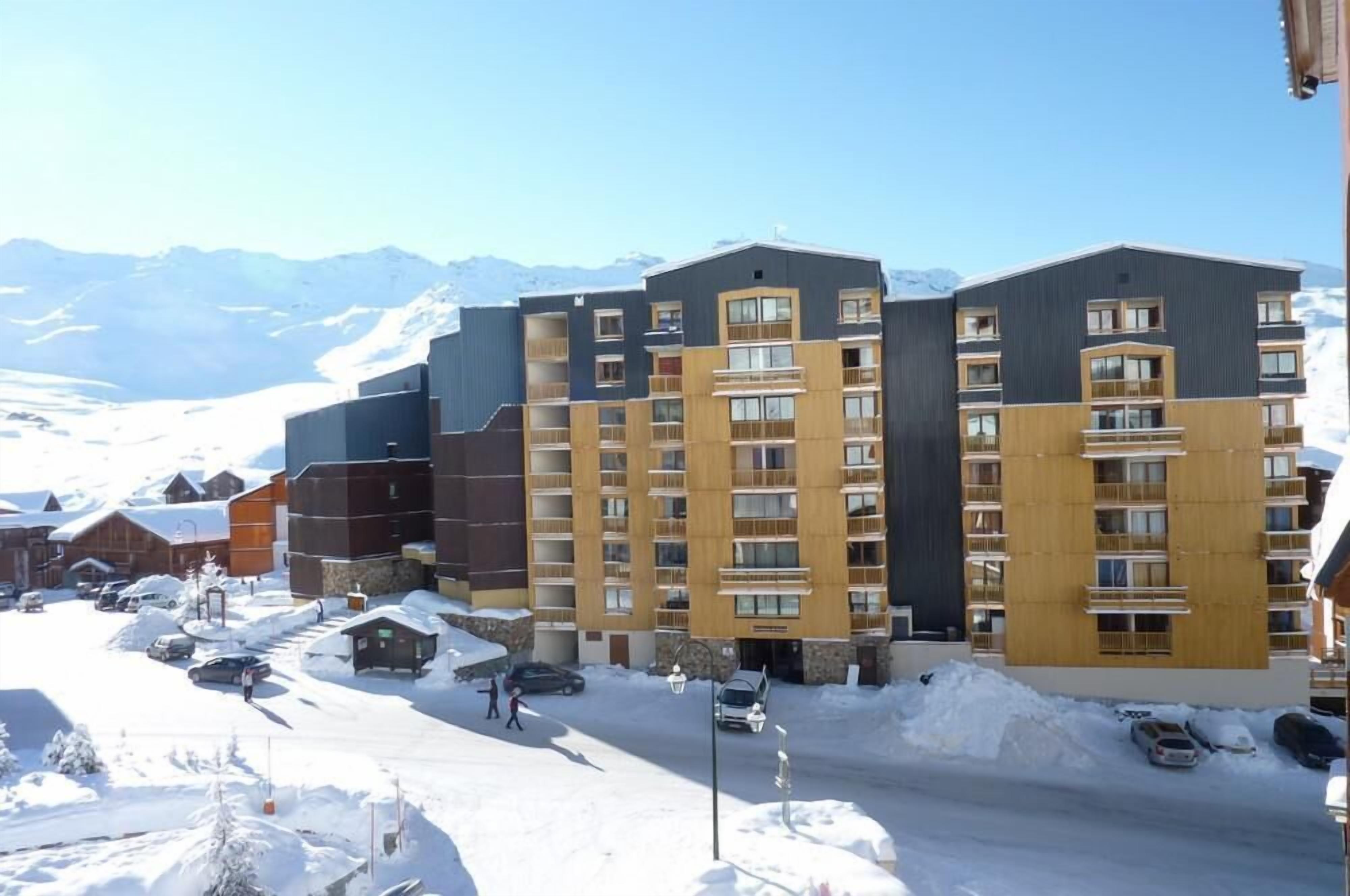 Un hôtel à plusieurs étages au design moderne, doté de balcons et de grandes fenêtres.