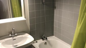Un baño con lavamanos blanco, bañera y ducha.