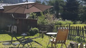 A patio area with a table and chairs, a wooden fence, and a mountain backdrop. - Chalet, fireplace or stove, tv, 62m², Pralognan-la-Vanoise (Pralognan-la-Vanoise)