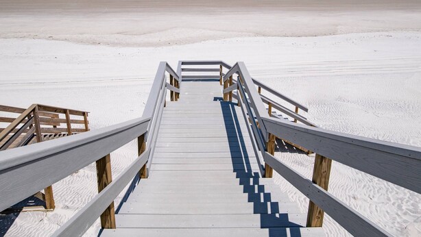 A wooden boardwalk leading to a beach with a clear view of the ocean. - Tradewinds (St. Augustine)