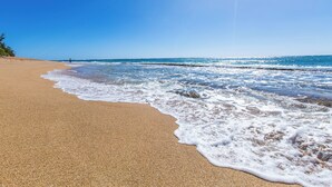 A beach with clear skies and calm waves. - Kailani #314, Top Floor, Walk to Kapaa Town and Beach (Kapaa)