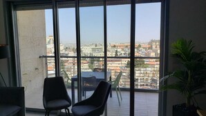 Ein Balkon mit zwei Stühlen, einem Tisch und einem Blumentopf.
