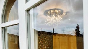 A bedroom with a bed, a chandelier, and a view of the outdoors through a glass door. - The Red Farm Relais & Spa (Iklin)