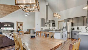 Una cocina amplia con una mesa de comedor de madera, gabinetes grises y una isla grande.