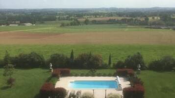 Una piscina al aire libre de temporada, sombrillas