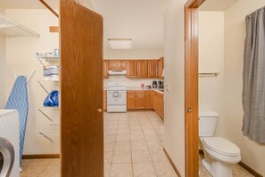 Una cocina pequeña con armarios de madera, una estufa blanca y un inodoro blanco.