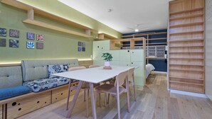 A compact living space with a dining area, built-in seating, and storage cabinets. - Serenity in the City - 1BD Studio, Wifi, CBD (Adelaide)