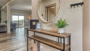Un salon avec une console en bois, un miroir et une plante.