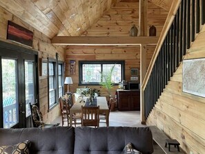 Cozy cabin-style accommodation with a seating area, dining table, and kitchen.