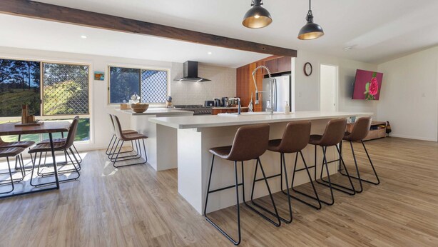 A modern kitchen with a large island, bar stools, and pendant lighting. - Bellemarie - An Unforgettable Farm Stay (Bellthorpe)