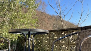 A patio area with a round table and wicker chairs, surrounded by a decorative fence and greenery. - Stay in a grand old house, close to Hebden Bridge with parking & pet friendly.   (Hebden Bridge)