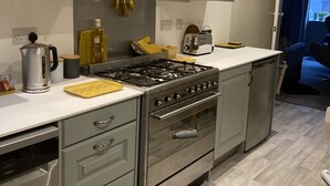 A modern kitchen with grey cabinets, stainless steel appliances, and a wooden countertop. - Stay in a grand old house, close to Hebden Bridge with parking & pet friendly.   (Hebden Bridge)