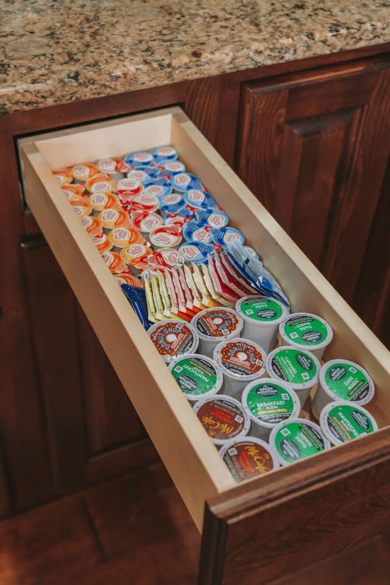 A drawer filled with various food items, including jars and containers, likely in a kitchen setting.