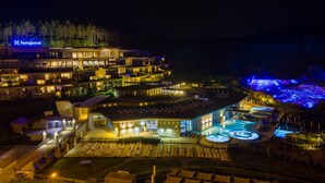Un hôtel moderne composé de plusieurs bâtiments, doté d’un espace extérieur aménagé et d’une piscine.