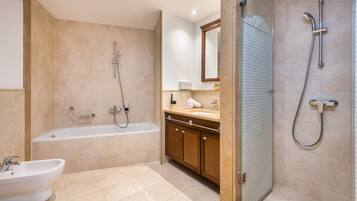 Een moderne badkamer met een bad, een wastafel en een douche.