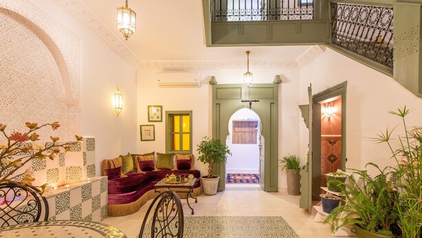 A spacious living area with a sofa, a dining table, and potted plants. - Private Riad for 4 people In Historic Neighborhood/ 5 minutes to Jemaa El-Fna 

 (Marrakesh)